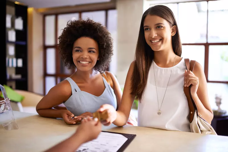 two-women-checking-into-hotel