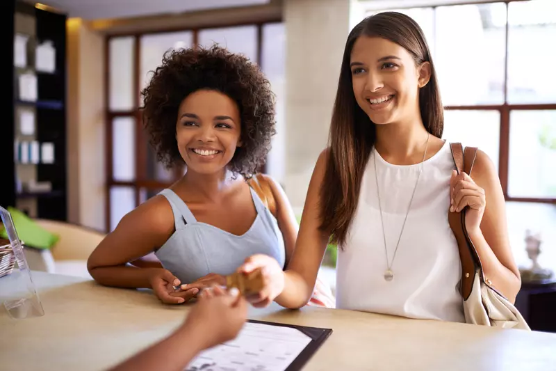two-woman-checking-into-hotel